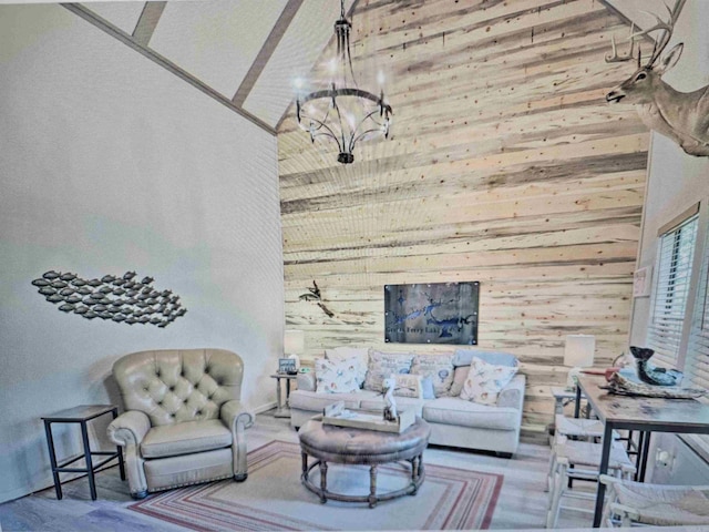 living room featuring wood walls, high vaulted ceiling, and a notable chandelier