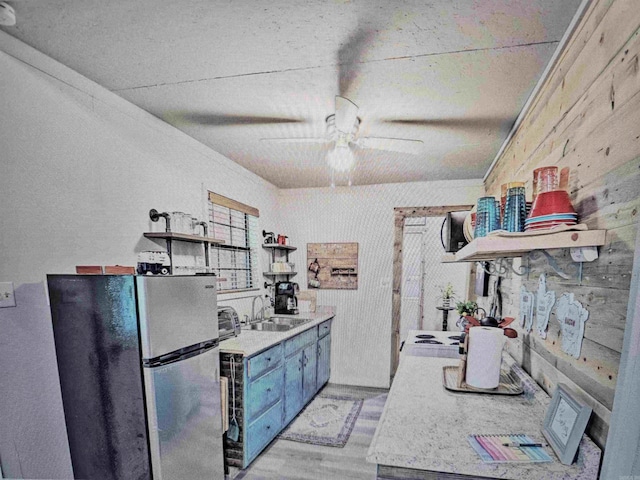 kitchen with a ceiling fan, open shelves, a sink, light wood-type flooring, and freestanding refrigerator