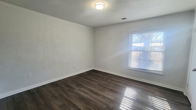609 Liberty, Marked Tree, AR 72365 - spare room featuring dark wood-style floors, a textured ceiling, baseboards, visible vents, and crown molding