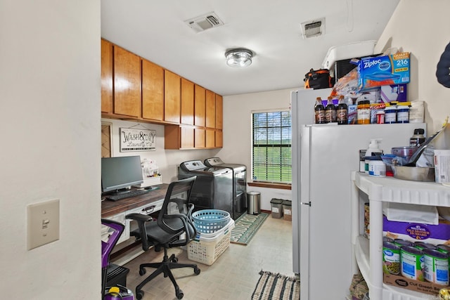 office space featuring built in desk, visible vents, and washing machine and clothes dryer