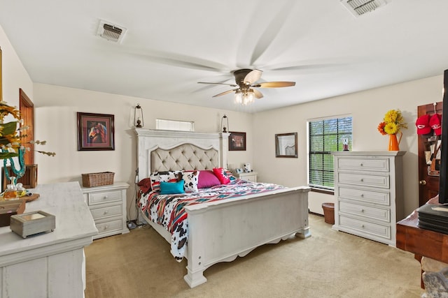 bedroom featuring visible vents, a ceiling fan, and light carpet