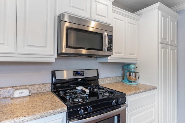 kitchen featuring white cabinets, stainless steel appliances, and light countertops