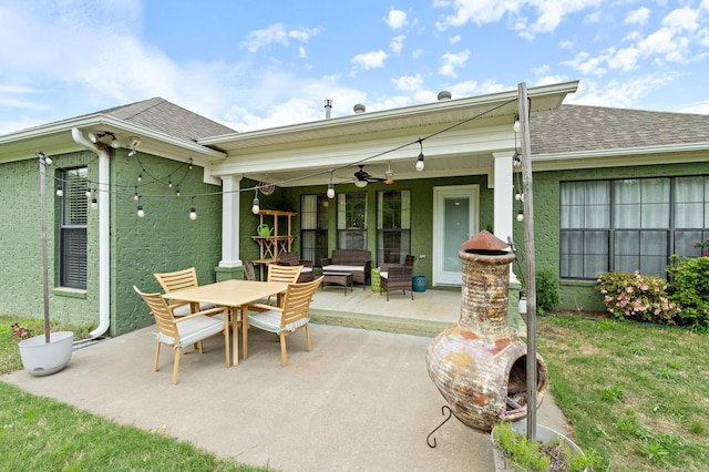 back of house featuring ceiling fan, a shingled roof, outdoor dining space, and a patio