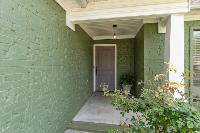 view of exterior entry featuring brick siding
