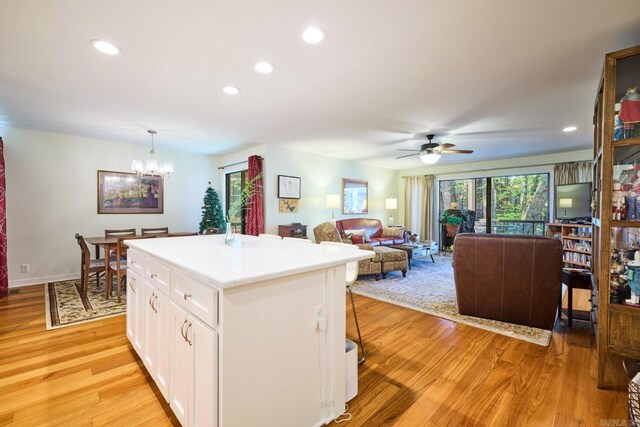 kitchen featuring white cabinets, light wood-style flooring, a kitchen breakfast bar, recessed lighting, and light countertops