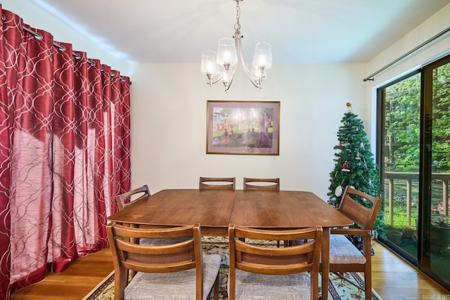 dining area with wood finished floors and a notable chandelier