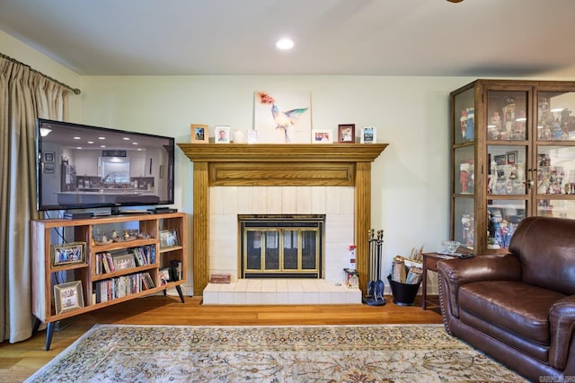 living room with recessed lighting, wood finished floors, and a fireplace