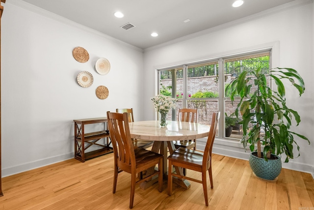dining area featuring light wood-type flooring, baseboards, visible vents, recessed lighting, and crown molding