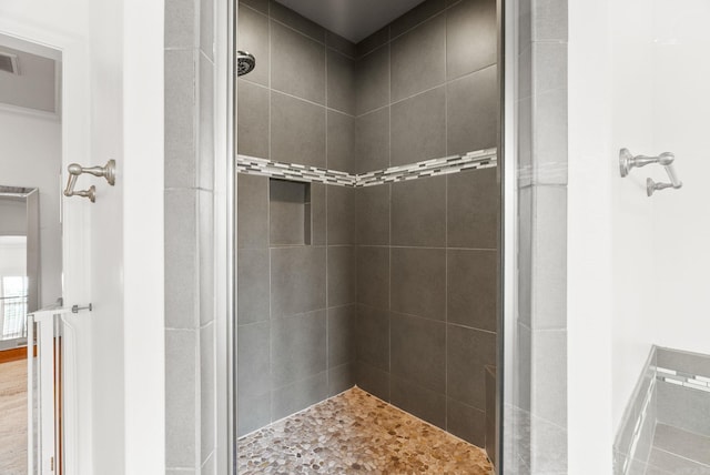 bathroom featuring a tile shower and visible vents