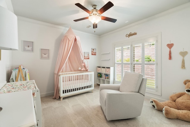 carpeted bedroom with a nursery area, ceiling fan, baseboards, ornamental molding, and visible vents