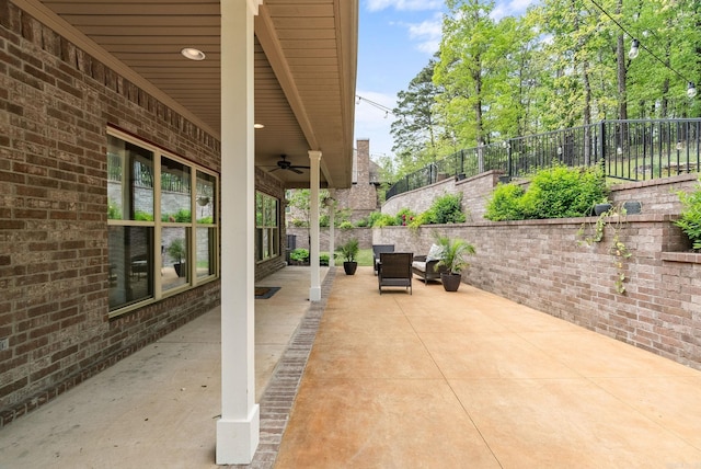 view of patio / terrace with ceiling fan and fence