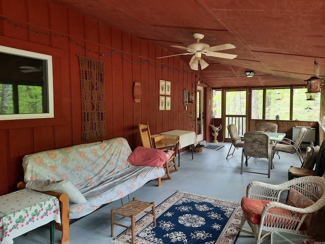 3986 Oak Grove Loop, Mountain View, AR 72560 - living area with concrete floors, wood walls, a ceiling fan, and a wealth of natural light