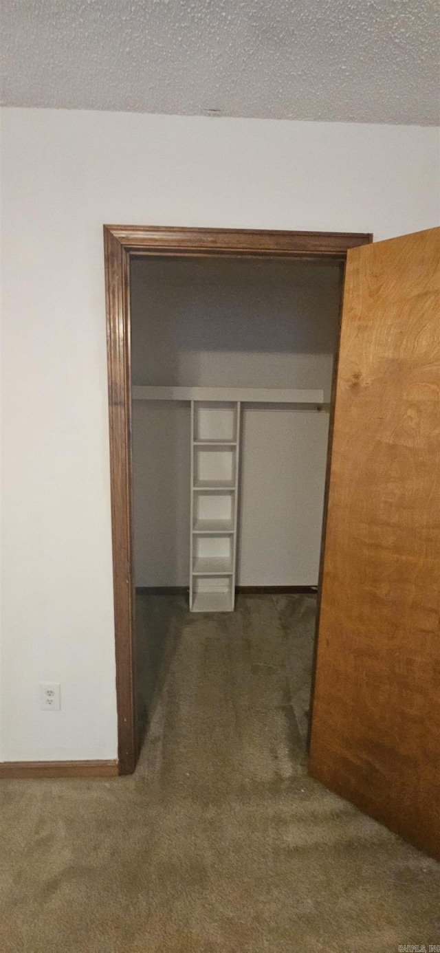 hallway featuring baseboards and carpet flooring