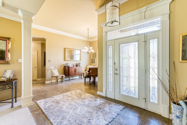 tiled entrance foyer featuring crown molding, baseboards, a notable chandelier, and decorative columns