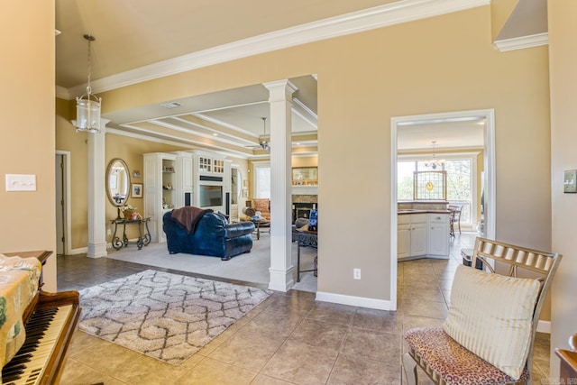 tiled living room featuring decorative columns, baseboards, a ceiling fan, a fireplace, and ornamental molding