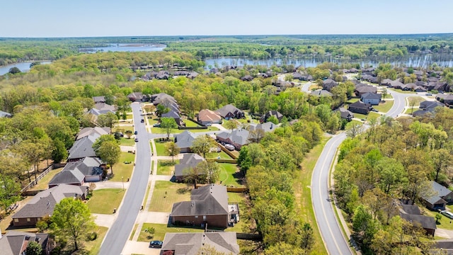drone / aerial view with a forest view, a residential view, and a water view