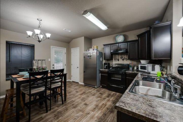 2104 Fern Valley Dr, Alexander, AR 72002 - kitchen featuring black electric range oven, freestanding refrigerator, a sink, a chandelier, and under cabinet range hood