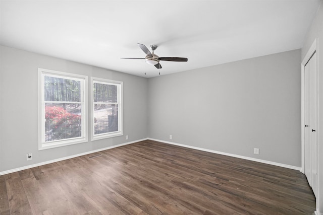interior space featuring visible vents, a ceiling fan, baseboards, and dark wood finished floors