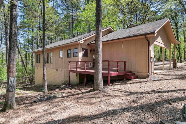 view of home's exterior featuring roof with shingles and a deck