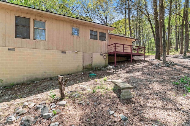view of side of property featuring crawl space and a deck