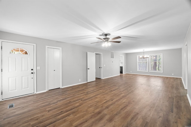 unfurnished living room featuring dark wood finished floors, baseboards, visible vents, and ceiling fan with notable chandelier