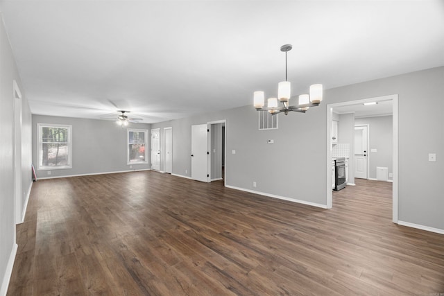 unfurnished living room featuring dark wood finished floors, baseboards, and ceiling fan with notable chandelier