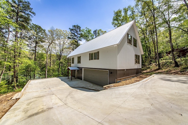 93 Pocahontas Ln, Greers Ferry, AR 72067 - view of side of home with an attached garage, driveway, and metal roof
