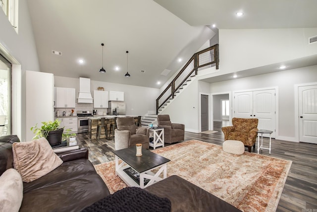 93 Pocahontas Ln, Greers Ferry, AR 72067 - living room featuring high vaulted ceiling, dark wood-style floors, visible vents, and stairway