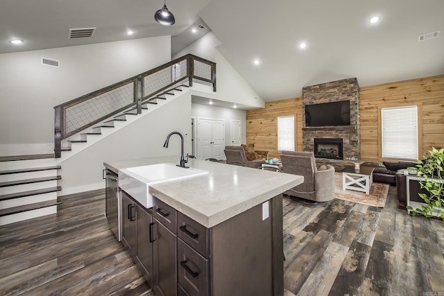 93 Pocahontas Ln, Greers Ferry, AR 72067 - kitchen with wood walls, visible vents, stainless steel dishwasher, a sink, and dark brown cabinetry