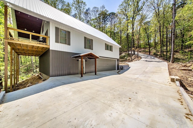 93 Pocahontas Ln, Greers Ferry, AR 72067 - view of property exterior featuring a garage, metal roof, a balcony, and concrete driveway