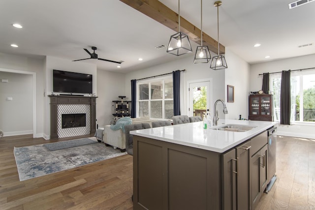 kitchen with light countertops, wood finished floors, visible vents, a ceiling fan, and a sink