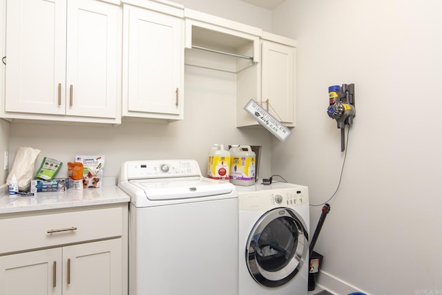 washroom featuring washing machine and dryer and cabinet space
