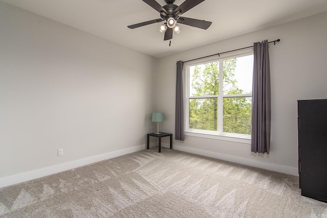 carpeted empty room with ceiling fan and baseboards