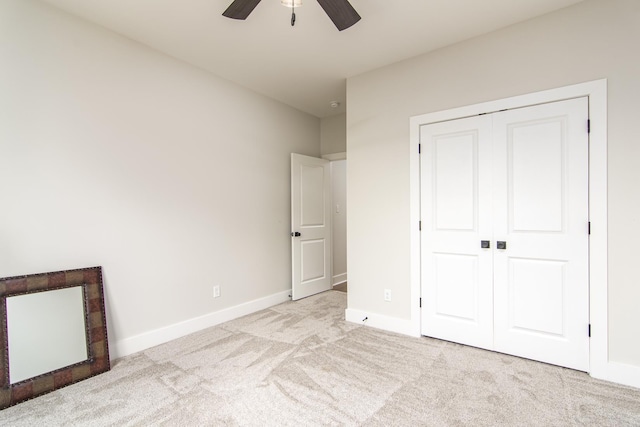 unfurnished bedroom featuring a closet, a ceiling fan, baseboards, and light carpet