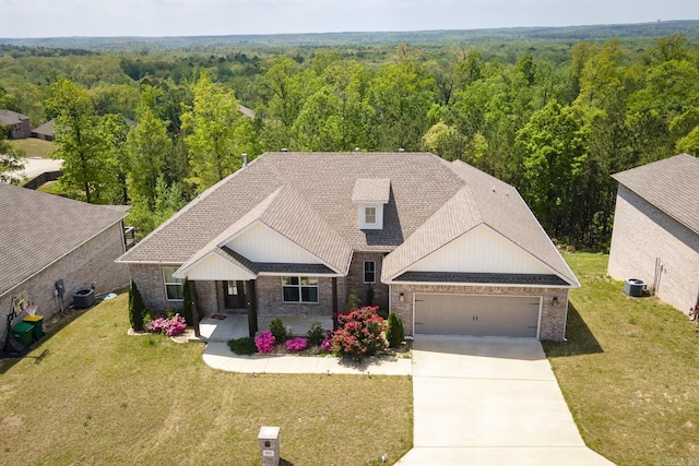 view of front of home featuring concrete driveway, brick siding, a view of trees, and a garage