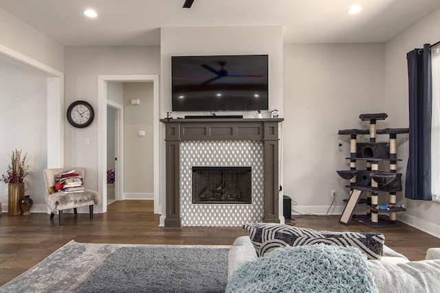 living area with a tiled fireplace, baseboards, wood finished floors, and recessed lighting