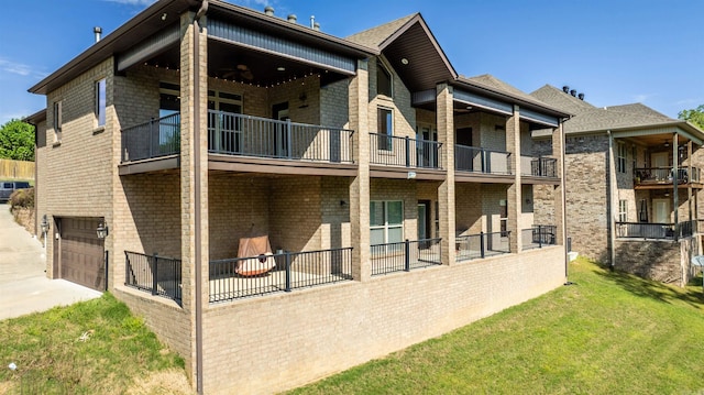 8908 Stillwater Rd, Sherwood, AR 72120 - back of house featuring an attached garage, a balcony, a yard, and brick siding