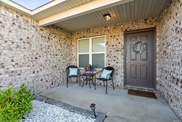 entrance to property featuring brick siding