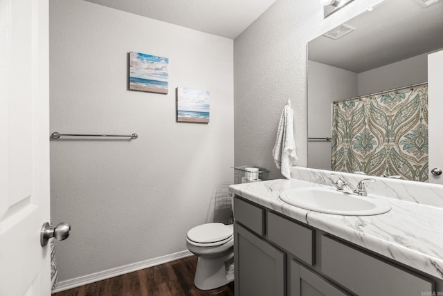 bathroom with wood finished floors, toilet, vanity, baseboards, and a shower with shower curtain
