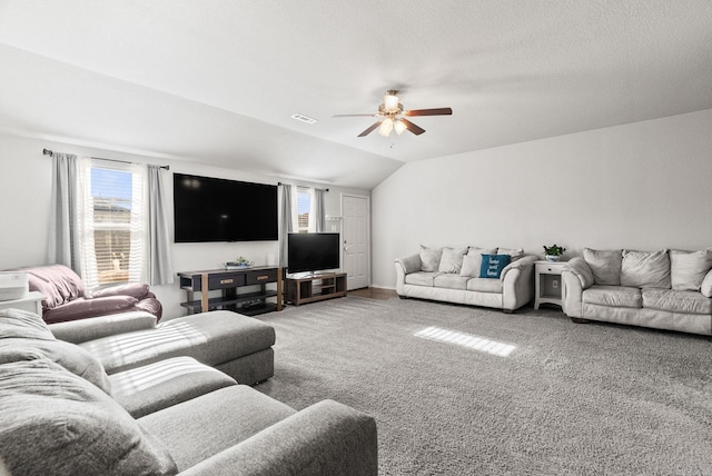 carpeted living room featuring vaulted ceiling, visible vents, and a ceiling fan
