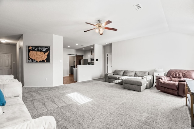 carpeted living area with a barn door, vaulted ceiling, ceiling fan, visible vents, and recessed lighting