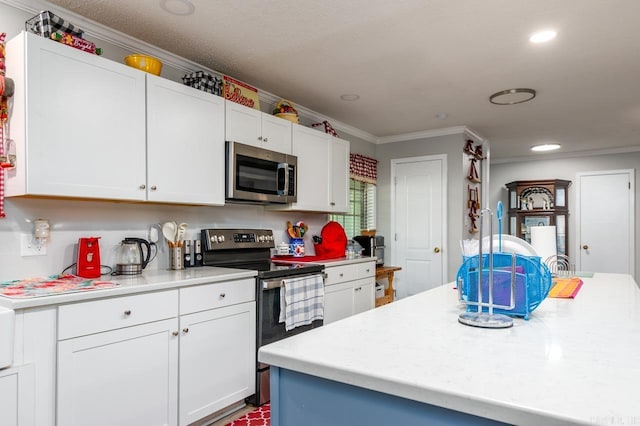 kitchen with ornamental molding, appliances with stainless steel finishes, white cabinetry, and light countertops