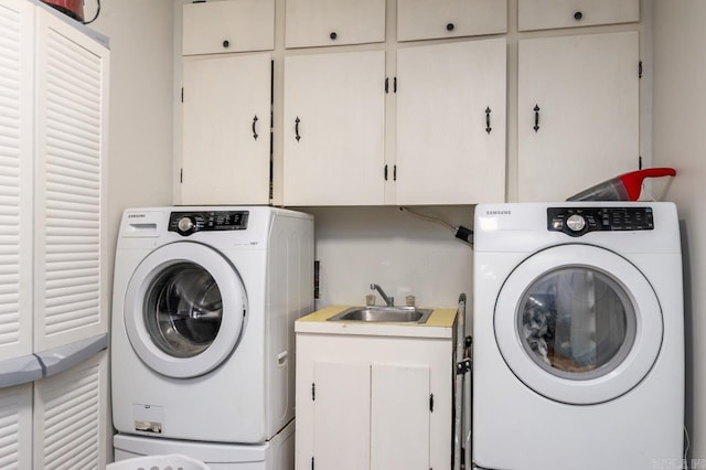 washroom with a sink, washer / clothes dryer, and cabinet space