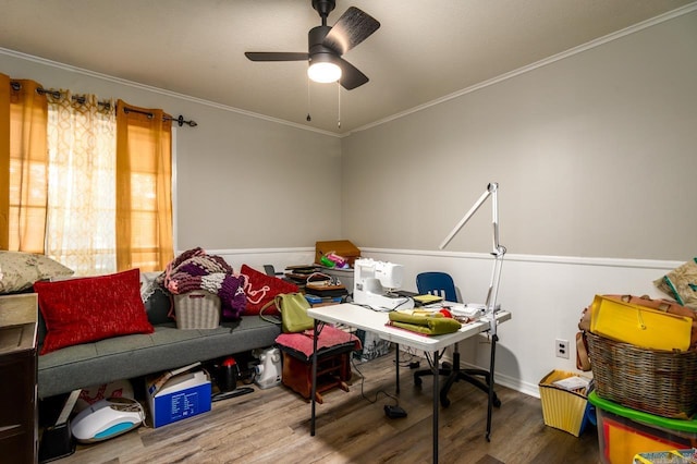 interior space with wood finished floors, a ceiling fan, ornamental molding, and wainscoting