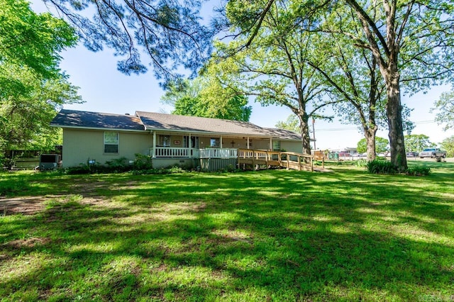 rear view of house featuring a wooden deck and a yard