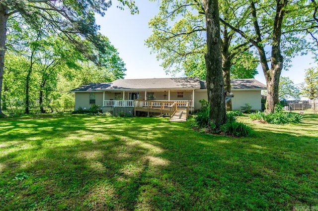 back of house featuring a lawn and a deck
