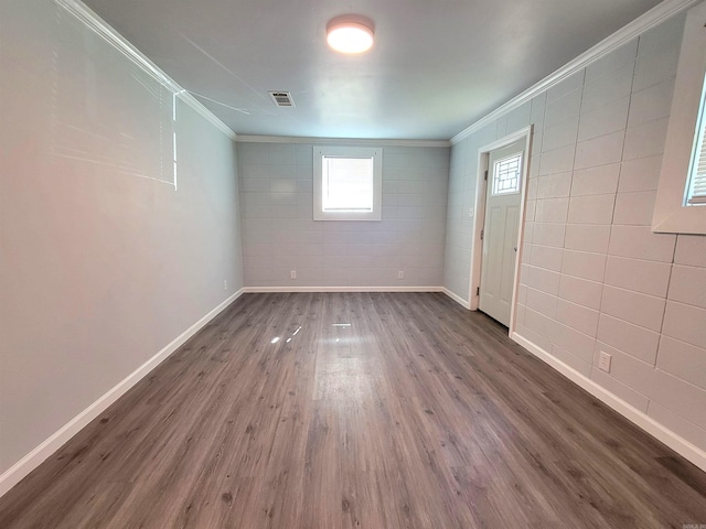 spare room featuring visible vents, baseboards, dark wood-style floors, and ornamental molding