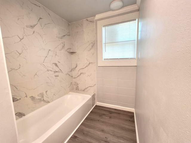 bathroom with baseboards, wood finished floors, and  shower combination