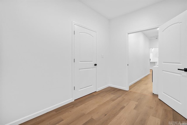 hallway featuring light wood-style floors and baseboards