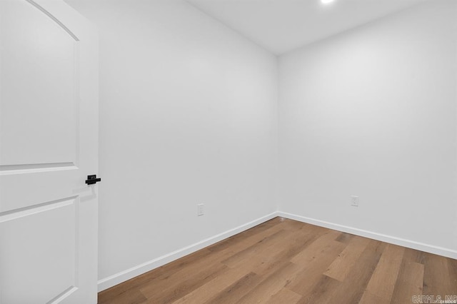 unfurnished room featuring baseboards, wood finished floors, and recessed lighting